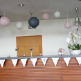 Décoration du bar de l'entrée de la salle : lanternes aux couleurs du mariage et compositions florales.