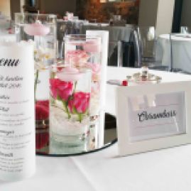 Centre de table avec fleurs plongées et bougies flottantes, menu photophore et nom de table encadré