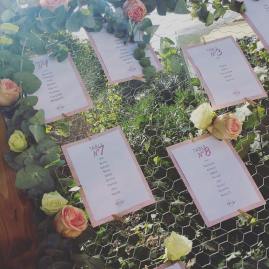 Décoration du plan de tables des mariés avec guirlande de feuillage et incrustation de roses