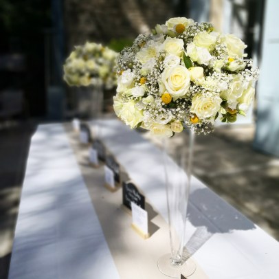 Composition florale blanche et jause sur vase haut pour décoration des buffets