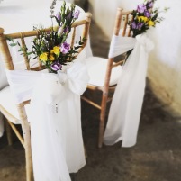 Décoration des chaises de mariés avec voilage et bouquets de fleurs