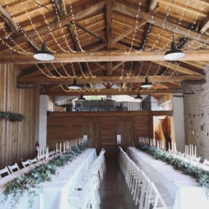 Installation et décoration d'une salle de mariage avec guirlande d'eucalyptus et guirlandes lumineuses